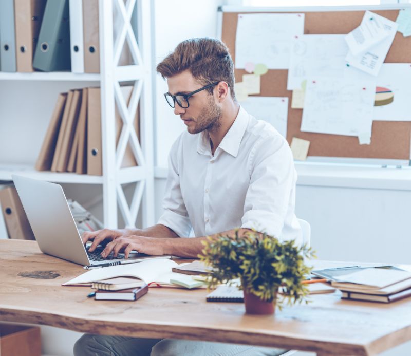 Ein Mann arbeitet am Laptop im Büro