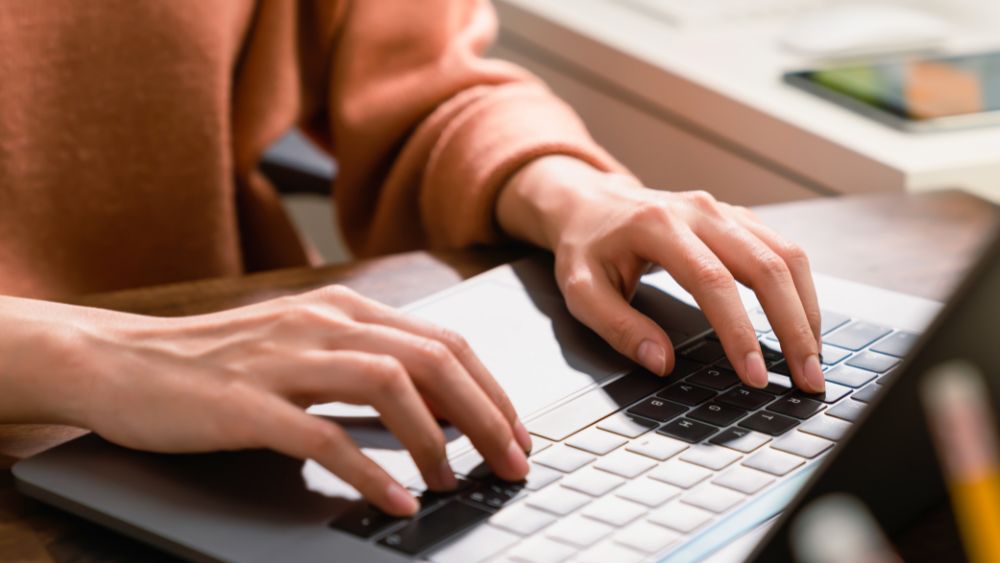 Close up of hands typing on laptop keyboard